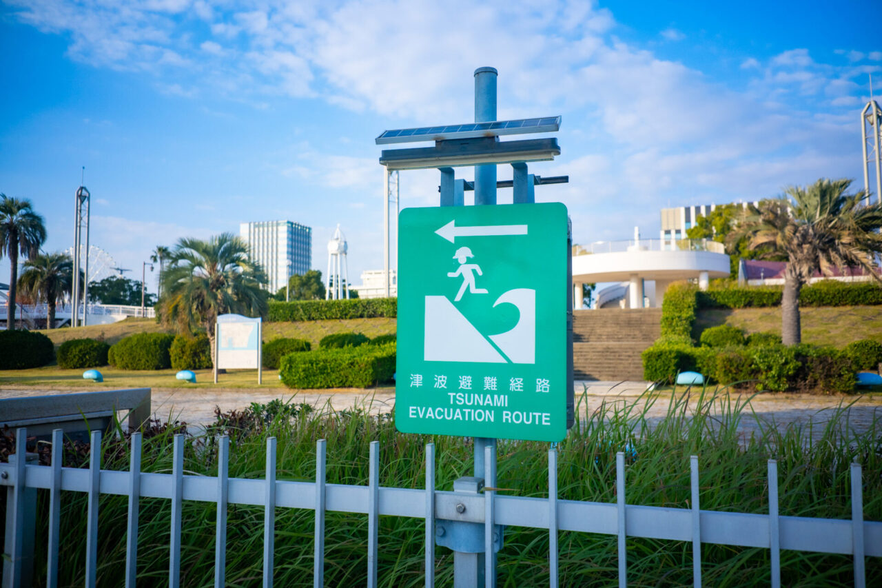 Tsunami evacuation route sign pointing toward a safe area in Japan
