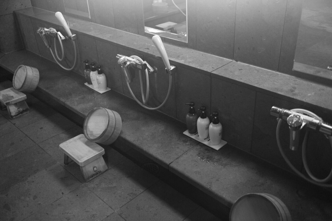 Low stools, showers, wash basins, and toiletries in a Japanese sento washing area