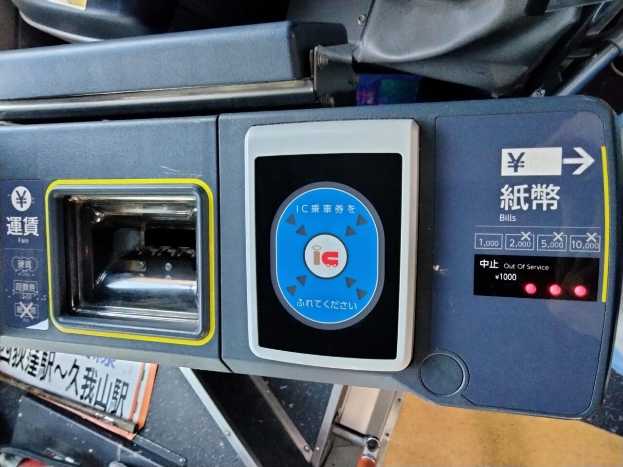Close-up of a bus fare box with an IC card reader and cash slot