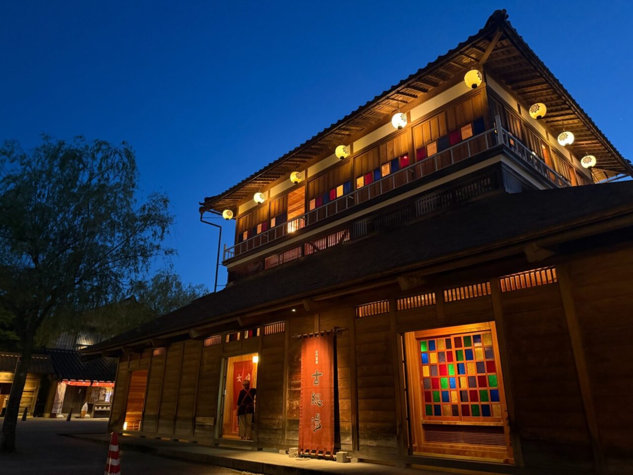 Traditional-style onsen hot-spring facility illuminated at dusk in Japan