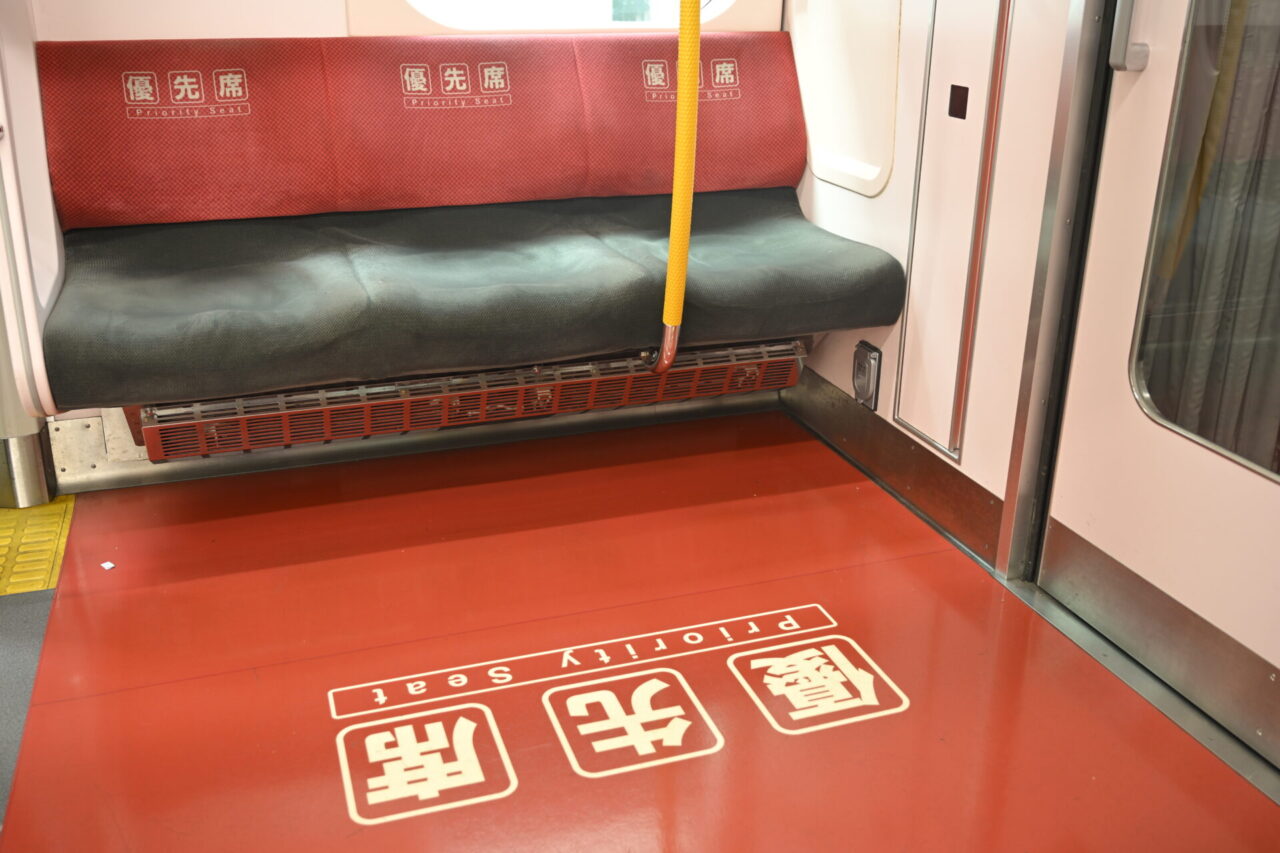 Red priority seating area marked on the seats and floor inside a Japanese train