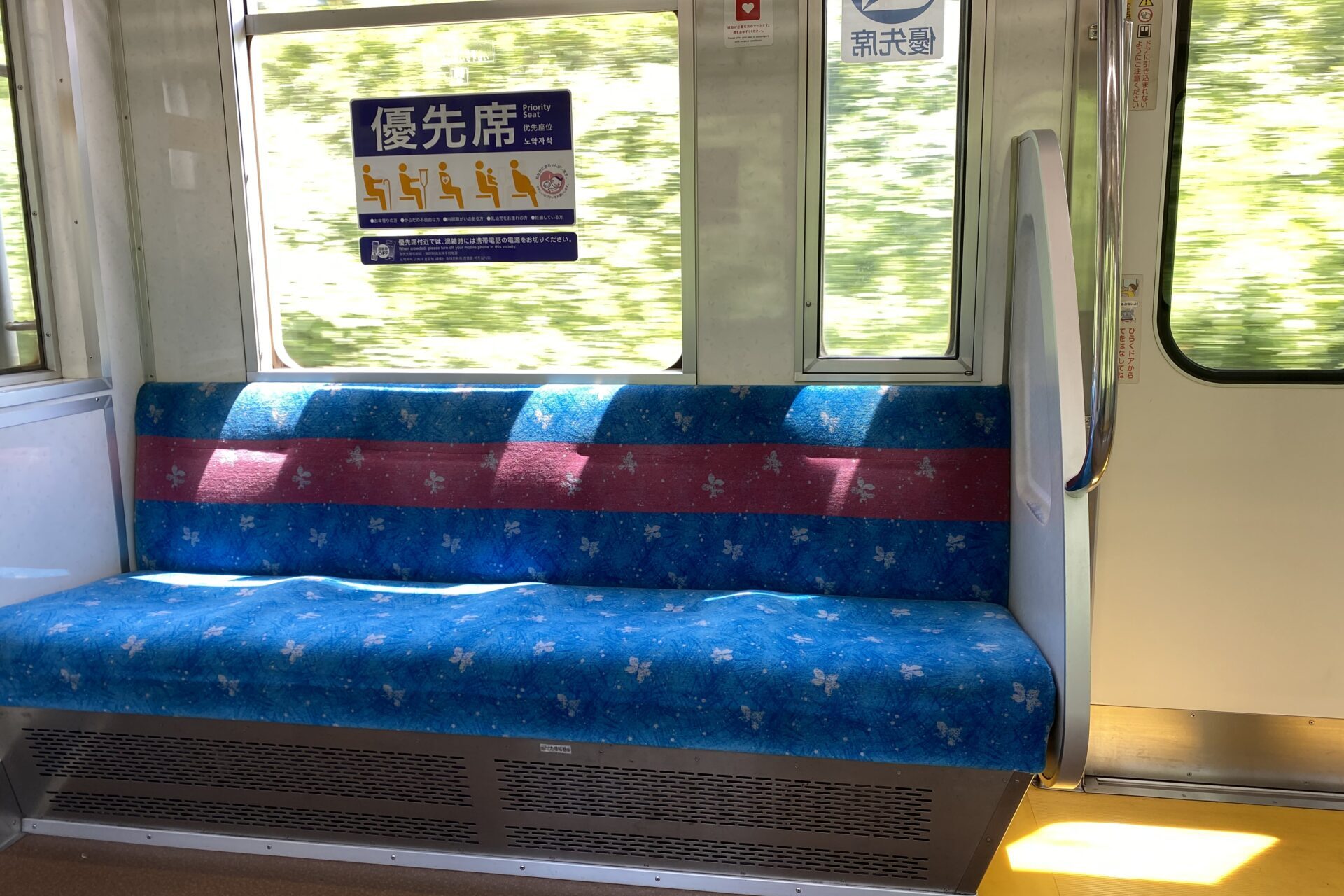 Priority seat sign above blue seats inside a Japanese train